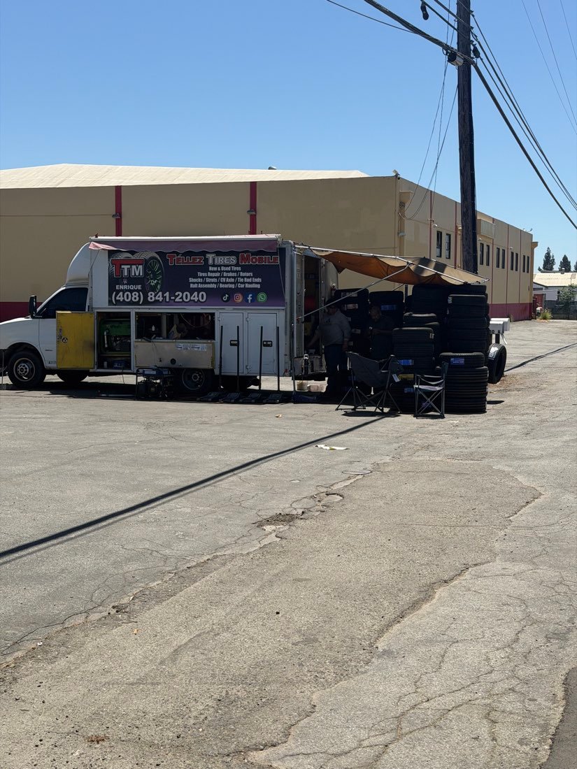 TTM service truck parked with the awning open and tires stacked beside it