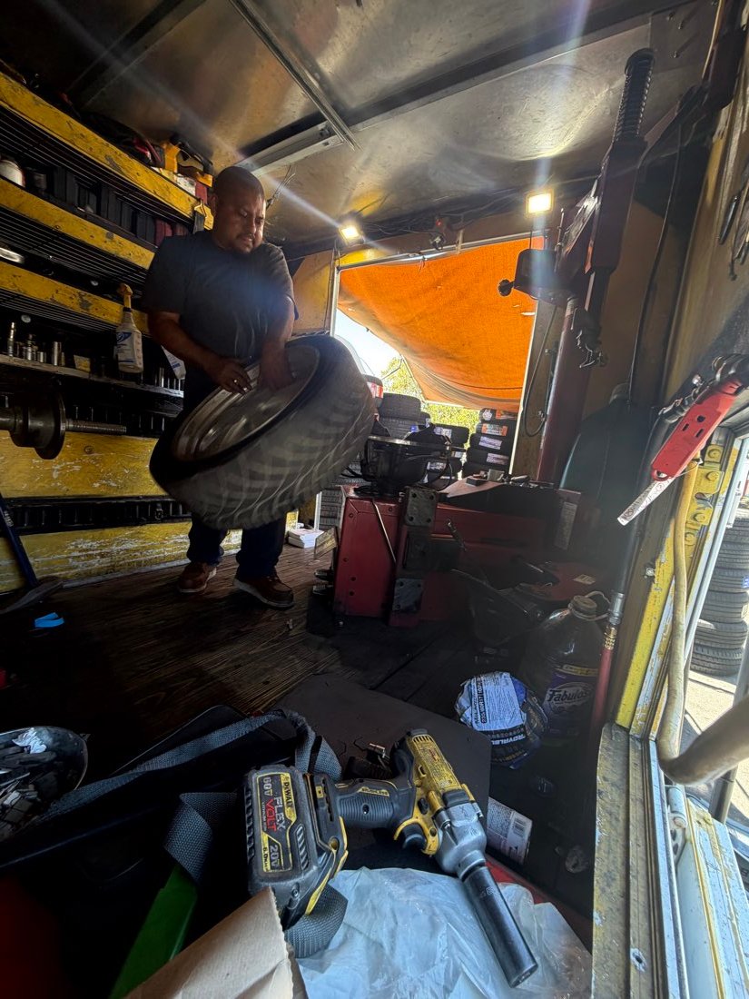 Technician lifting a tire onto the service rack