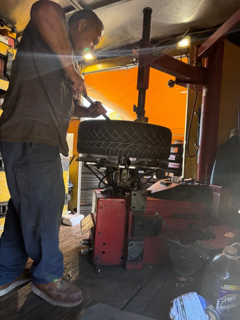 Technician using a breaker bar on a wheel mounted on the tire changer