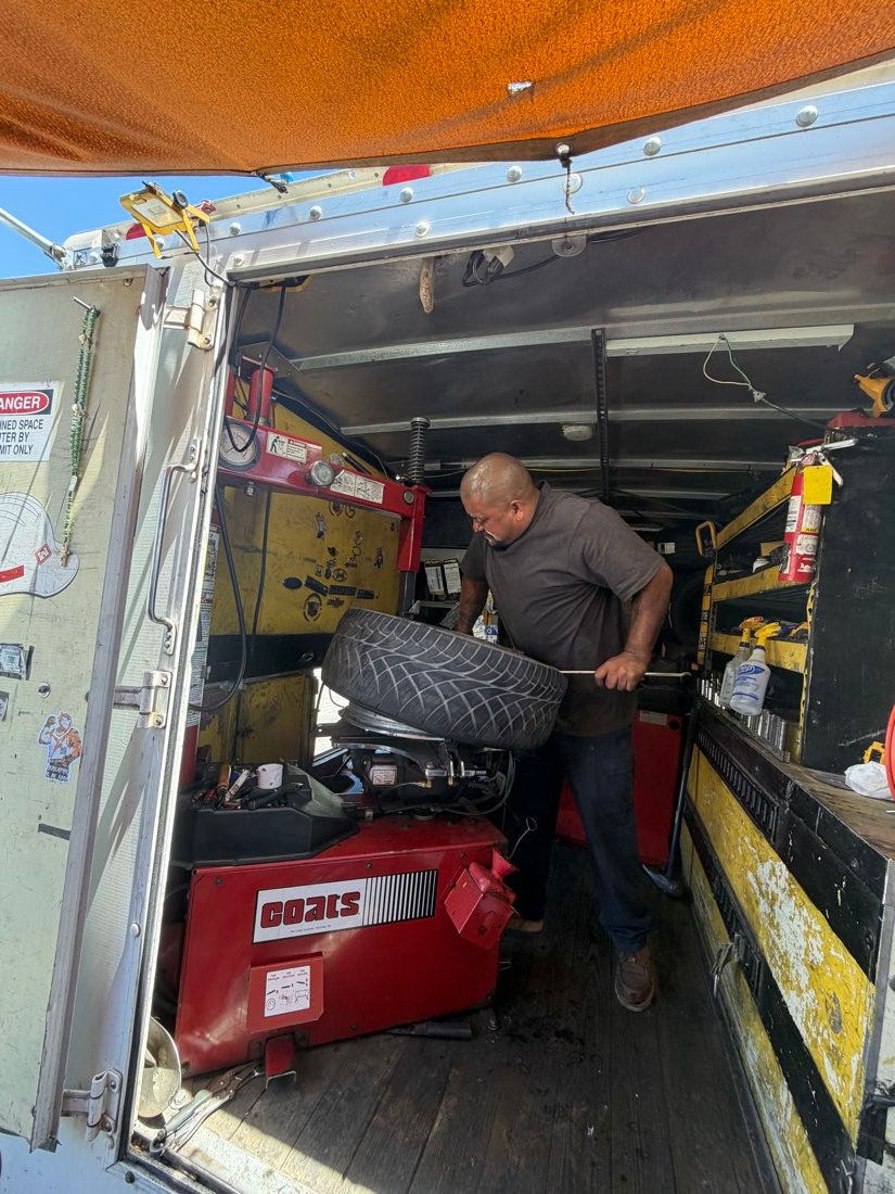 Technician using a wrench on a mounted tire
